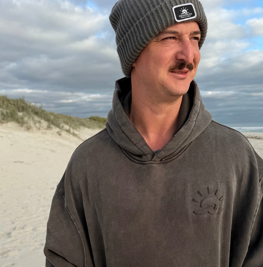 Man at beach wearing Aquaholics Anonymous hoodie